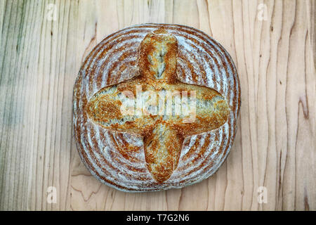 Artisan crusty loaf of freshly baked sourdough bread focaccia boule. traditional Homemade sourdough Boule bread with crust on a wooden board Stock Photo