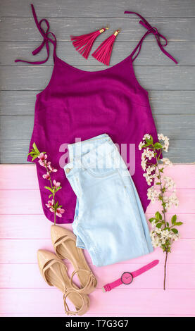 Set of trendy female clothes, accessories and blossoming branches on wooden background, flat lay Stock Photo