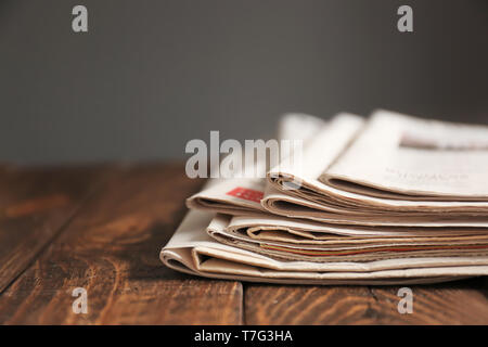 Pile of newspapers on wooden table Stock Photo