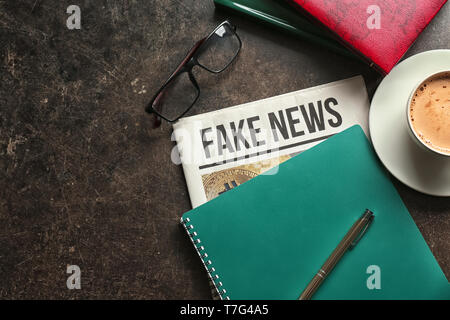 Newspaper with notebook and cup of coffee on table Stock Photo