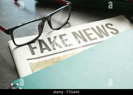 Newspaper with notebook and glasses on table Stock Photo