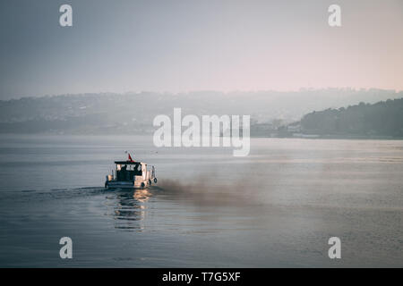 small boat filling the air with smoke and pollution from his engine Stock Photo