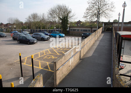 Ramp at Sudbury Town Station, which gives access for disabled people. Space for disabled parking is also visible on the carpark. Stock Photo