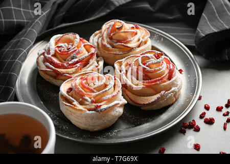 Metal tray with rose shaped apple pastry on table Stock Photo