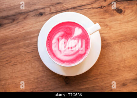 Cup of trendy beetroot latte on table. Stock Photo