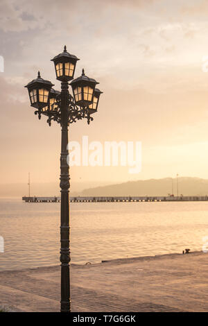 poetic vintage streetlight in a sunset in front of the sea Stock Photo