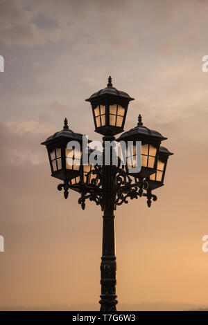 poetic vintage streetlight in a sunset in front of the sea Stock Photo