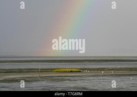 Rainbow over the Wadden sea, Germany Stock Photo
