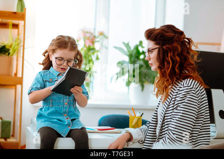 Mother and daughter wearing glasses spending time in office Stock Photo
