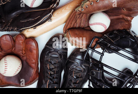 Vintage and modern baseball equipment including bats, balls gloves and face mask on a white background Stock Photo