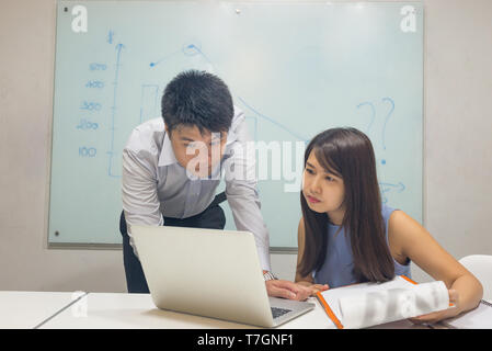 Business team analyzing and discussing about data on laptop Stock Photo