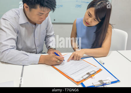 Asian businessman signing contract in the office Stock Photo