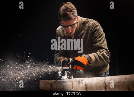 Handsome man using wood sanding machines belt sander Stock Photo