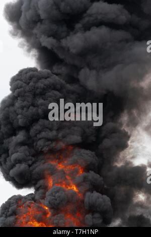 Black motion clouds of strong fire smoke covered sky. Defocus and ...
