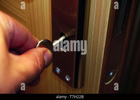 Unlocking the door with the key on the hand Stock Photo