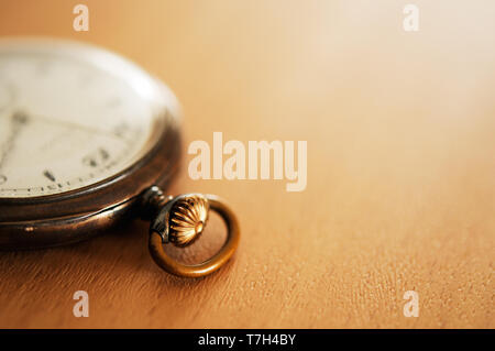 Old pocket watch on a wooden table. Selective focus and shallow depth of field. Stock Photo