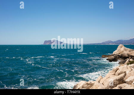 Detail of beach with turquoise and blue sea with Altea and Benidorm in background. Stock Photo