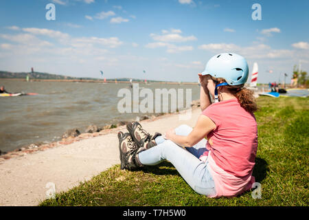 Close up picture of a woman wear inline roller blades near a strand of a lake Stock Photo