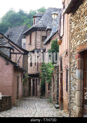 Street in Conques, historic town along the Via Podiensis, also know as Le Puy Route, in southern France. Next to Abbey-Church of Saint-Foy. Stock Photo