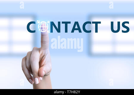 Woman touching contact us button with earth globe and telephones drawing on transparent display as futuristic high-tech concept Stock Photo