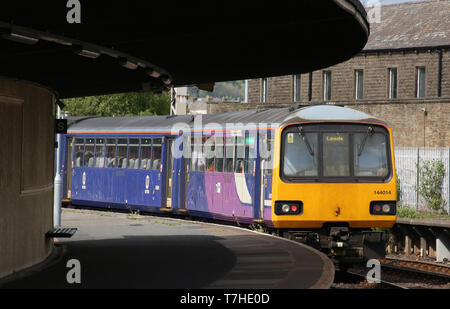 Class 144 Pacer diesel multiple unit number 144014 in Northern livery leaving platform 2 at Carnforth railway station on 6th May 2019. Stock Photo
