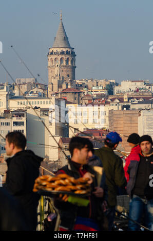 A Turkish man carries Simit on a tray on his head on the Galata Tower, Istanbul, Turkey Stock Photo