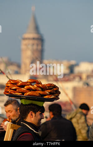 A Turkish man carries Simit on a tray on his head on the Galata Tower, Istanbul, Turkey Stock Photo