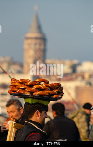 A Turkish man carries Simit on a tray on his head on the Galata Tower, Istanbul, Turkey Stock Photo