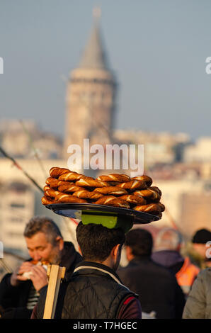 A Turkish man carries Simit on a tray on his head on the Galata Tower, Istanbul, Turkey Stock Photo