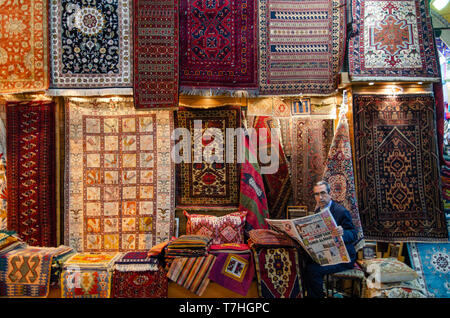 Catching up with the news, a carpet seller in the  Grand Bazar, Istanbul, Turkey Stock Photo