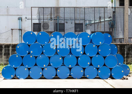 empty recycle blue steel chemical tanks for oil fuel barrels stacked in a row at the factory storage. background and texture Stock Photo