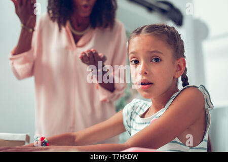 Portrait of girl feeling scared while mother screaming at her Stock Photo