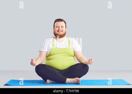 Overweight man practicing yoga on white background Stock Photo - Alamy