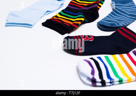 Different colorful textile clothes for legs, socks on white background with copy space. Selective focus. Shopping concept Stock Photo