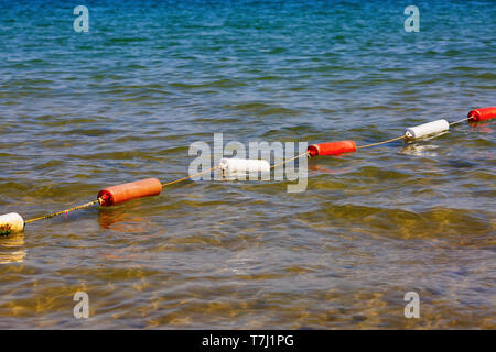 Fencing for swimming. Protective buoys on sea surface. Safety fencing on water. Stock Photo