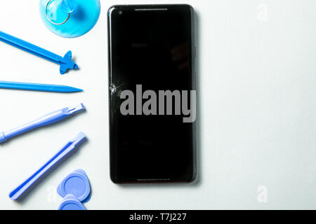 Broken phone with tools for repair, service concept Stock Photo