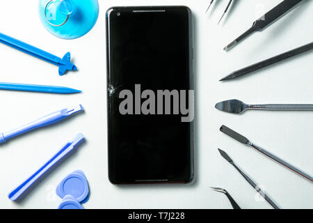 Broken phone with tools for repair, service concept Stock Photo