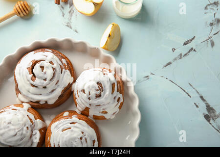 Dish with glazed cinnamon buns on table Stock Photo