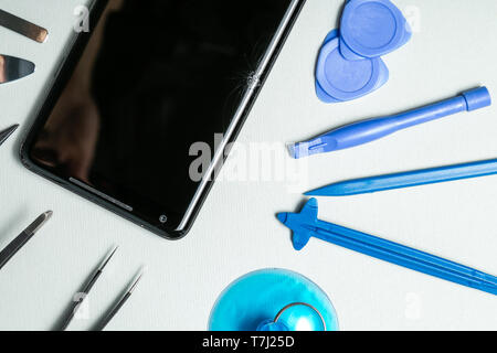 Broken phone with tools for repair, service concept Stock Photo