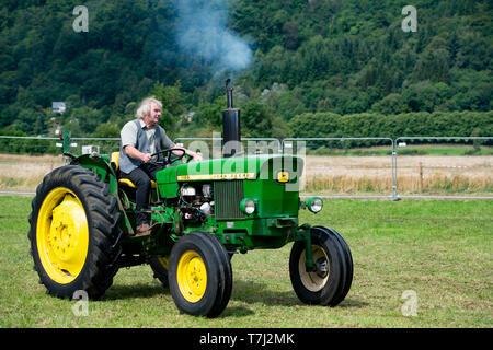Man driving vintage John Deere Tractor, UK Stock Photo