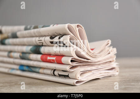 Pile of various newspapers on table Stock Photo