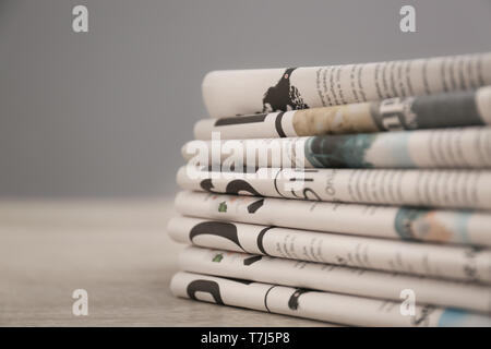 Pile of various newspapers on table Stock Photo