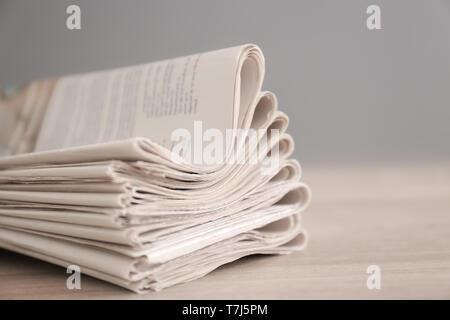 Pile of various newspapers on table Stock Photo