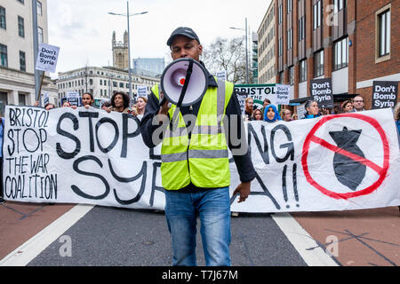 Protesters carrying signs and chanting slogans stand outside a Tesla ...