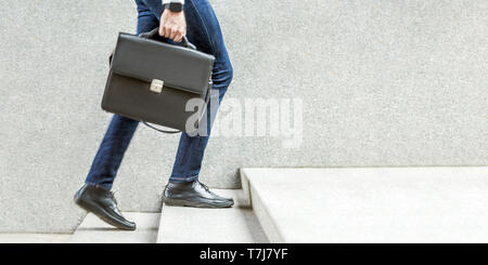 Businessman with black briefcase in hand walking up on stairs. business goal, improvement, progress, Increase and growth concept. Outdoor closeup shot Stock Photo