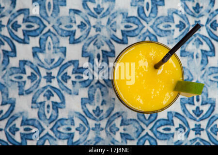 Fresh tropical fruit smoothie mango juice on blue background. Copy space. Top view. Stock Photo