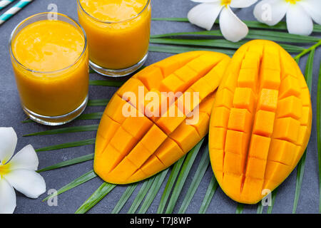 Fresh tropical fruit smoothie mango juice and fresh mango on grey background. Stock Photo
