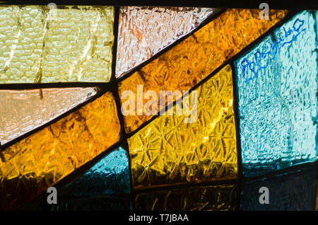 Rectangular and round stained glass window with red rose. Abstract geometric colorful background. Multicolored stained glass church window with irregu Stock Photo