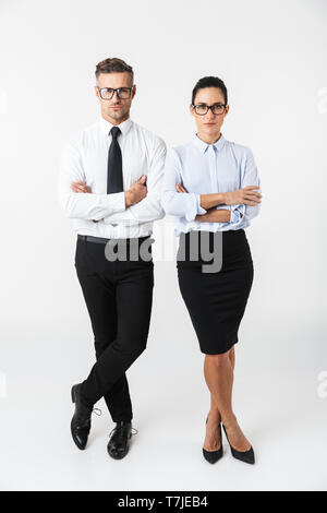 Full length of a confident colleagues couple wearing formal clothing standing isolated over white background, arms folded Stock Photo