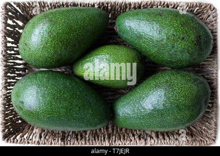 Overhead Shot of Five Avocados in a Basket Stock Photo